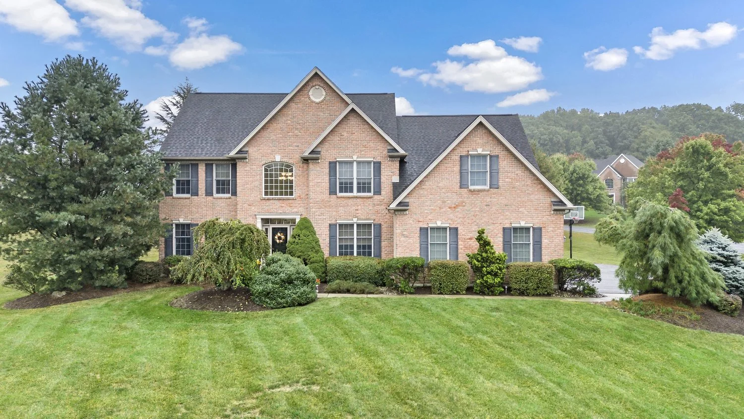 Elevated exterior view of a brick home with a landscaped lawn