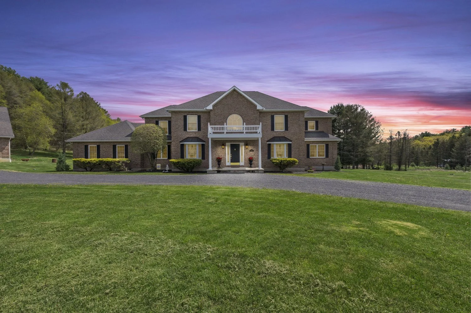 A two-story brick home photographed at twilight by C.U. Imagery