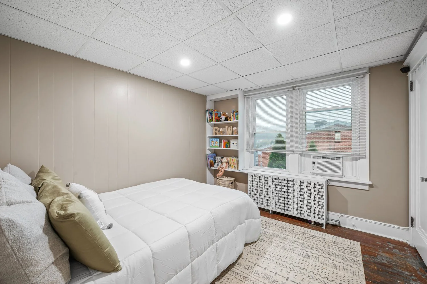 Bright bedroom photographed to show its windows, layout and finishes